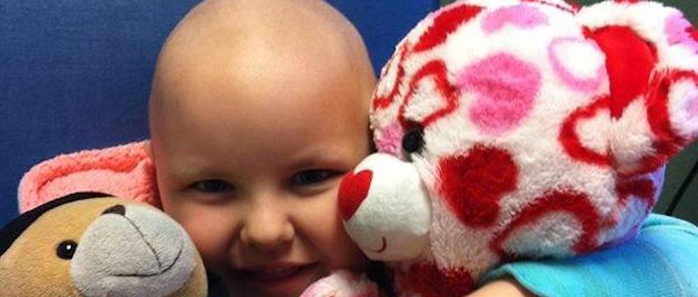 Girl hugging stuffed animals donated by Katharine's Wish